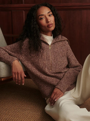 A person wearing a VARLEY - SHERIDA HALF-ZIP KNIT SWEATER IN GINGERBREAD FLECK, a brown speckled boucle yarn sweater with a collared half-zip neckline.