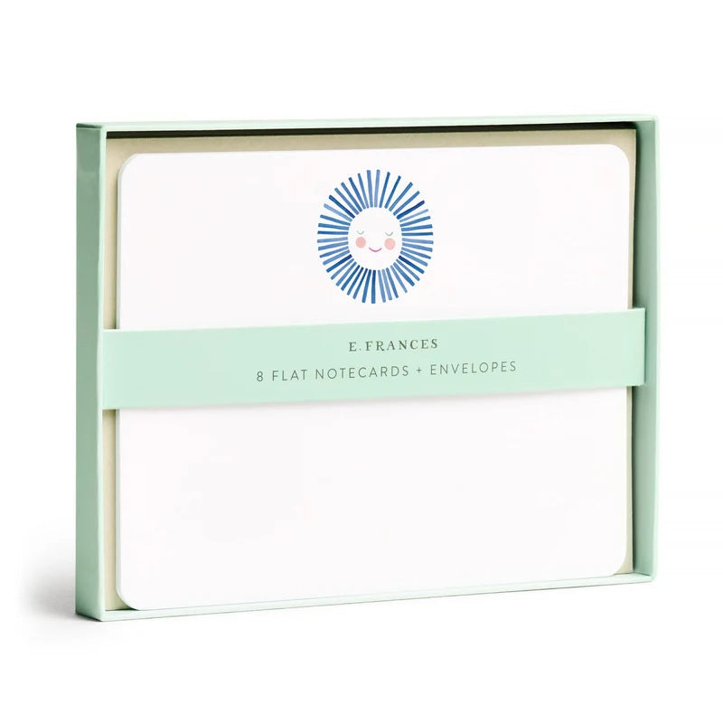 The E. FRANCES - FLAT NOTES BLUE SUNSHINE by E. FRANCES PAPER features a blank notecard with rounded corners and a cheerful sun at the top, paired with a plain white envelope—perfect illustrated stationery for hand-written notes on any occasion.