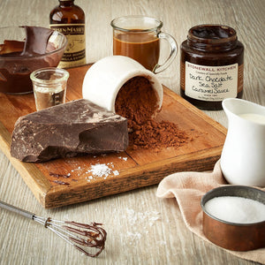 A jar of STONEWALL KITCHEN- DARK CHOCOLATE SEA SALT CARAMEL SAUCE from Stonewall Kitchen, featuring a green lid and a white label that includes details such as “gluten free” and “net weight 354g (12.5 oz).”.
