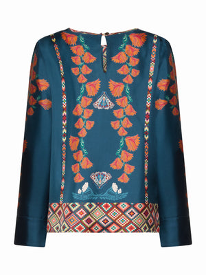 The FRANCO FERRARI - ALOE SILK BLOUSE features long sleeves, teal silk with orange floral embroidery, geometric borders at the hem and neckline, and a button accent on the back collar.