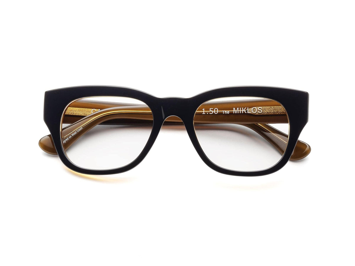 The CADDIS - MIKLOS PROGRESSIVE READERS by CADDIS are black, thick-rimmed rectangular eyeglasses with scratch-resistant lenses and beige inner arms, displayed against a white background.