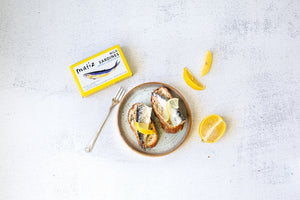 MATIZ ESPANA's MATIZ - SARDINES WITH LEMON comes in a yellow box featuring a sardine illustration. Key highlights include "Wild caught in the Eastern Atlantic," "2.3 grams of Omega-3s," "High in Calcium," and "Rich flavor." Contains 120g (4.2 oz); includes Spanish olive oil and lemon essence.
