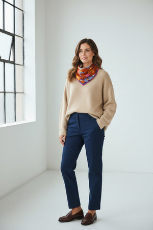 Fearrington Village Inoui Editions Toutou wool scarf in orange with floral print worn by a woman