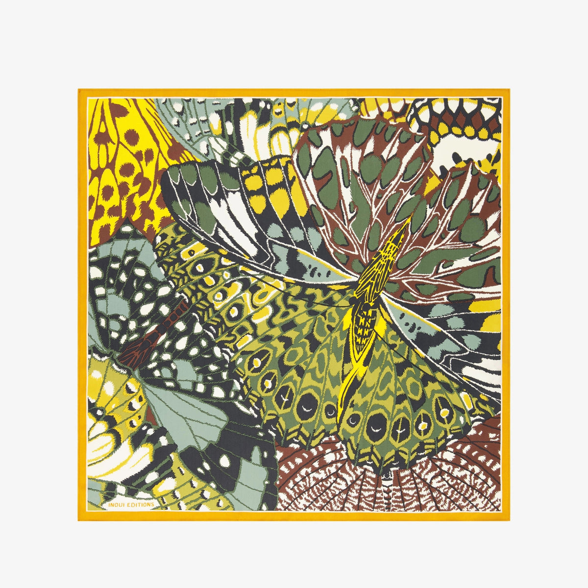 A woman with dark hair wears a beige blazer and the INOUI EDITIONS - PAPILLON (BUTTERFLIES) Silk Scarf in Green by INOUI, a versatile accessory made in India, featuring vibrant yellow, black, and green designs, against a plain white background.