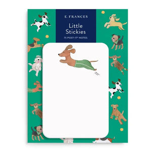 E. FRANCES PAPER's "Little Stickies Off Leash" notepad features a brown dachshund in green pants, with a backing card decorated with playful cartoon dogs on a green background—perfect dog stationery for any pup lover.