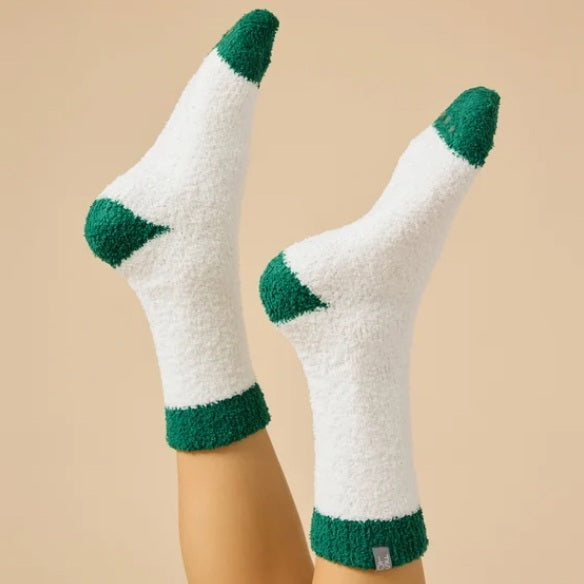 A pair of SOFTIES - MARSHMALLOW CREW SOCKS IN WHITE WITH GREEN HEEL worn on legs, featuring a white marshmallow design with green heels, toes, and cuffs.