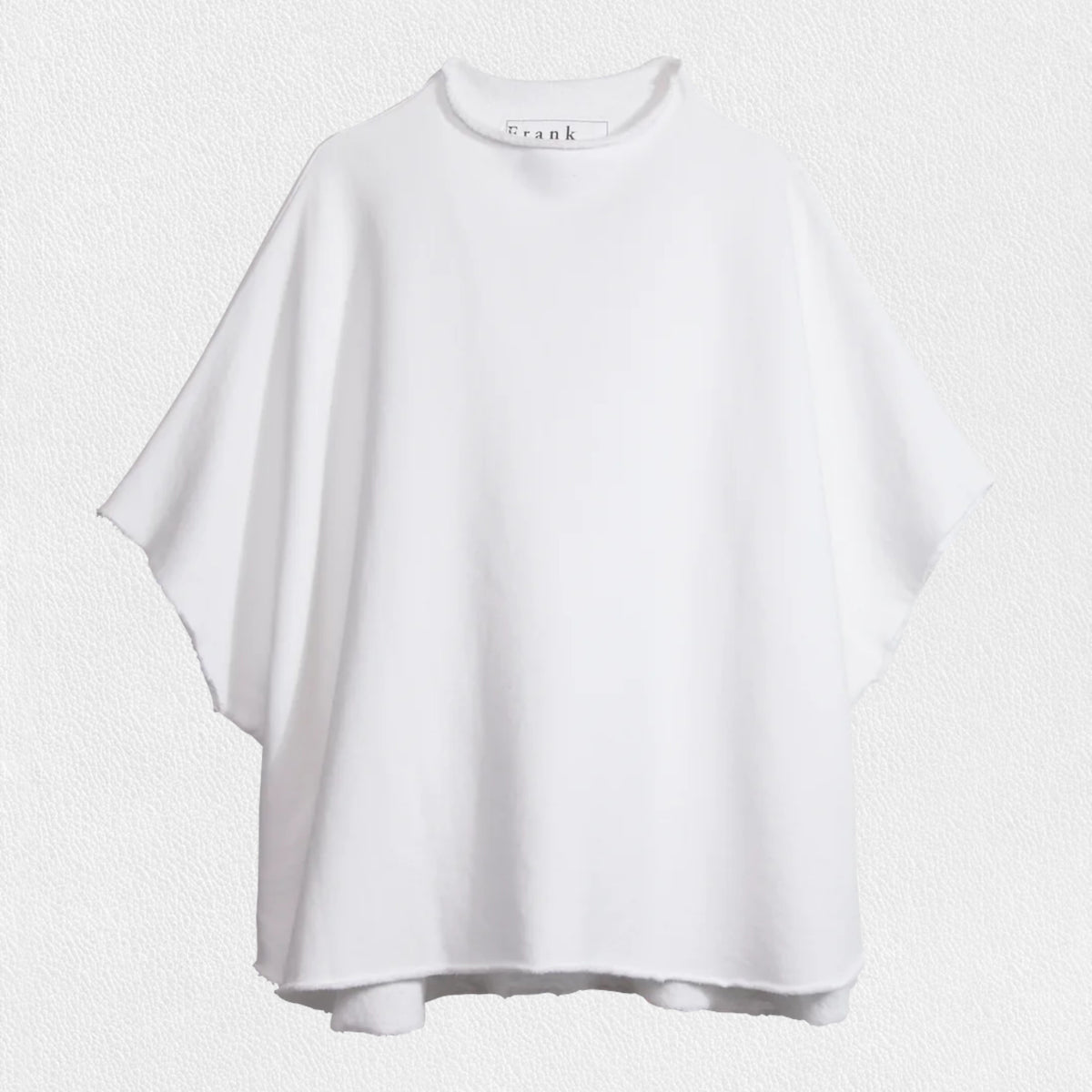 Displayed against a textured white background, the FRANK AND EILEEN - AUDREY FUNNEL NECK CAPELET IN WHITE exudes sophistication with its loose-fitting, short-sleeved design. Featuring a high, round neckline and minimalist style, this capelet is made from 100% Cotton Fleece by the renowned brand FRANK &amp; EILEEN, making it a refined addition to any wardrobe.