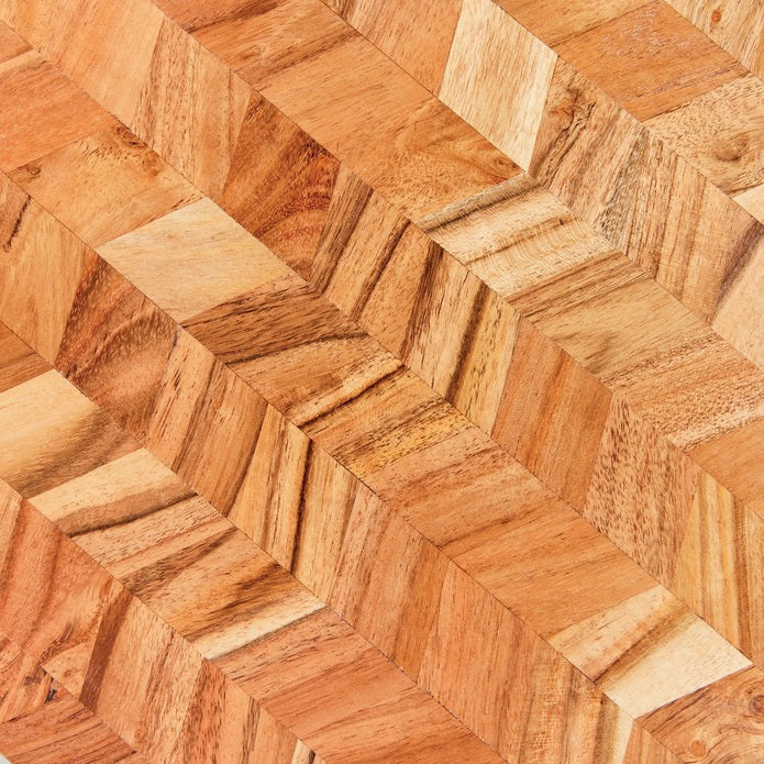 Close-up of the NAPA HOME AND GARDEN RENATA SERVING BOARD, featuring acacia wood in a chevron pattern with natural grain and light brown tones—ideal for an elegant charcuterie presentation.