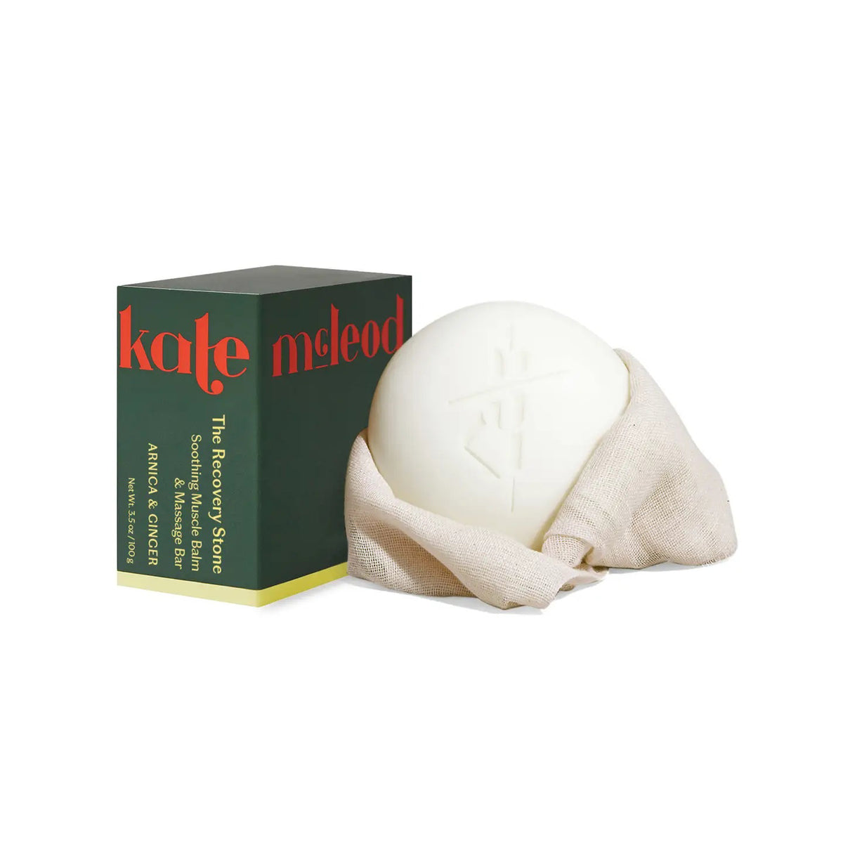 A person in a white robe rubs the KATE MCLEOD RECOVERY STONE | SOOTHING MUSCLE BALM on their thigh, with text highlighting its benefits: soothes sore muscles, reduces stress, is mess-free, and deeply nourishes dry skin.