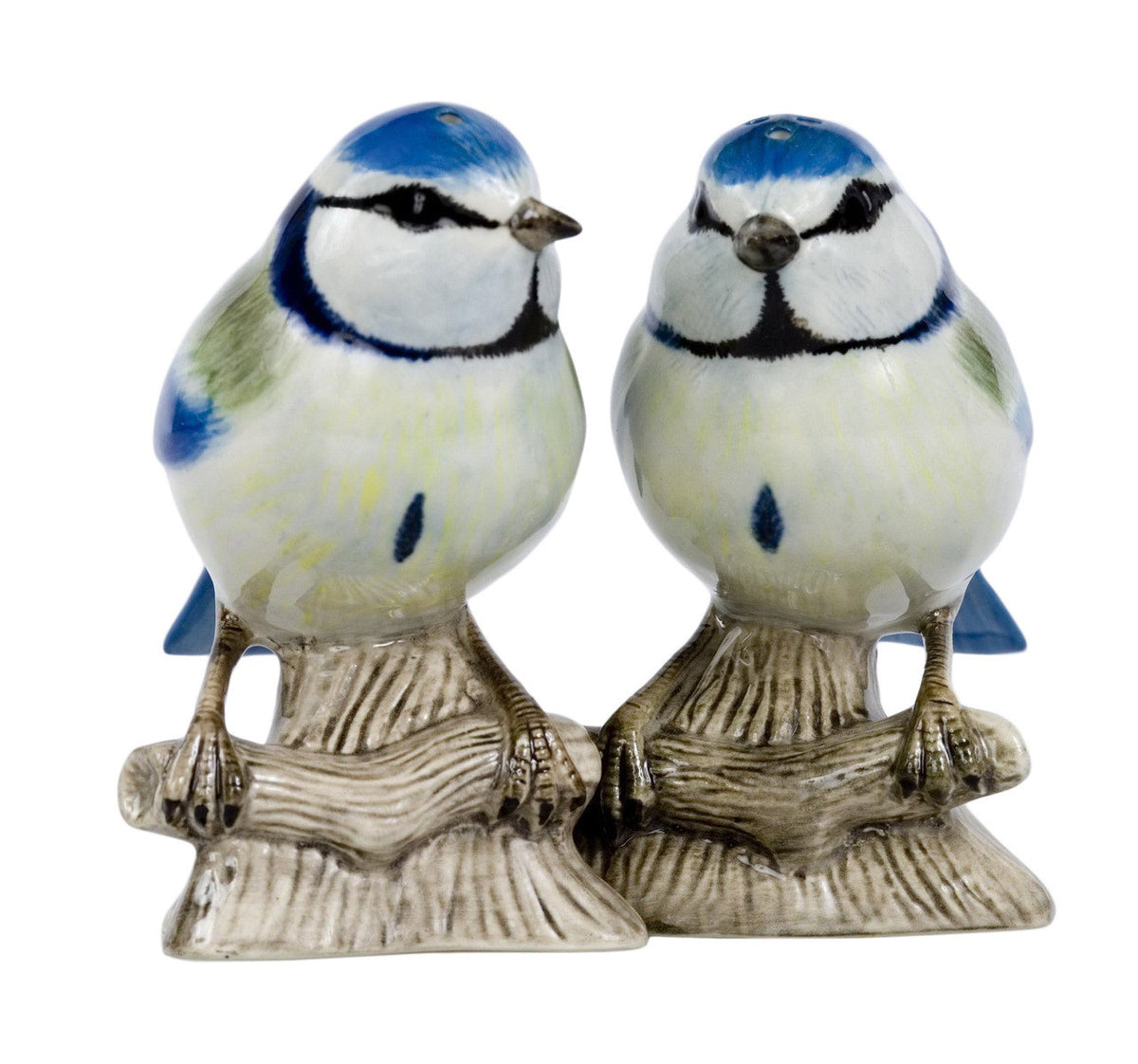 The QUAIL CERAMICS - BLUE TIT SALT AND PEPPER SET by QUAIL DESIGNS features handpainted stoneware shakers with lifelike blue, white, and yellow details sitting on brown tree stump bases—a charming addition to any table.