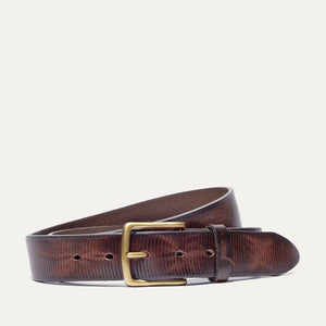 Close-up of the WILL LEATHER GOODS Embossed Crescent Belt in brown, handcrafted from full-grain leather with a silver buckle and two metal rivets, displayed on a white background.