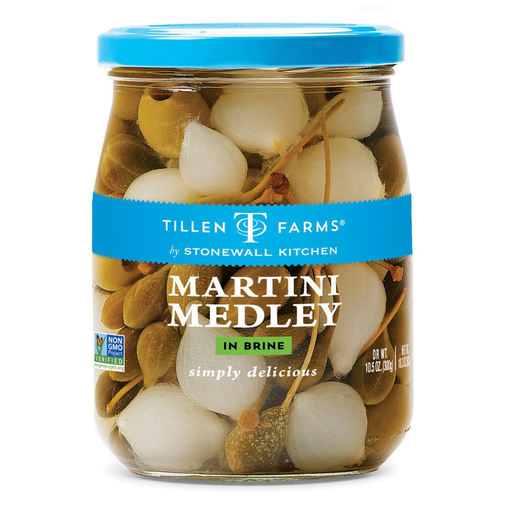 Introducing the STONEWALL KITCHEN - TILLEN FARMS MARTINI MEDLEY. This 10.5 oz (296g) jar, adorned with a blue label and white text declaring it "Non-GMO," contains a delectable assortment of pickled vegetables in brine, including onions and green olives. It's the ideal choice for creating perfect cocktail garnishes for your martinis.