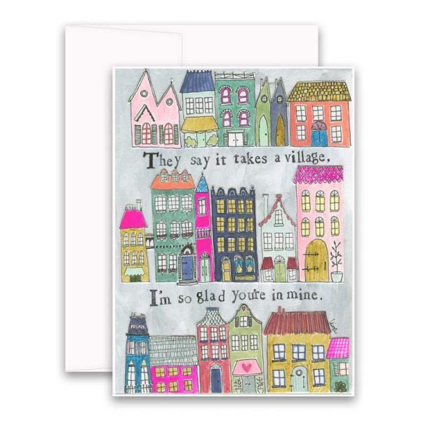 The CURLY GIRL DESIGNS - TAKES A VILLAGE CARD by CURLY GIRL DESIGN, INC features a whimsical illustration of colorful houses. Above the houses, the text reads, "They say it takes a village," and below the houses, it says, "I'm so glad you're in mine.
