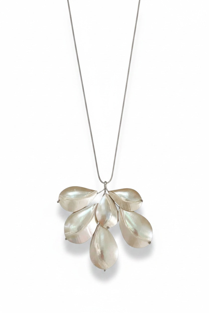 The ANN LIGHTFOOT - CHAMBERED NAUTILUS SHELL SPRAY NECKLACE by ANN LIGHTFOOT is showcased on a white jewelry bust against a plain white background. Reminiscent of an elegant spray necklace, this piece features overlapping metallic chambered nautilus shell pendants suspended from an adjustable sleek black nylon cord.