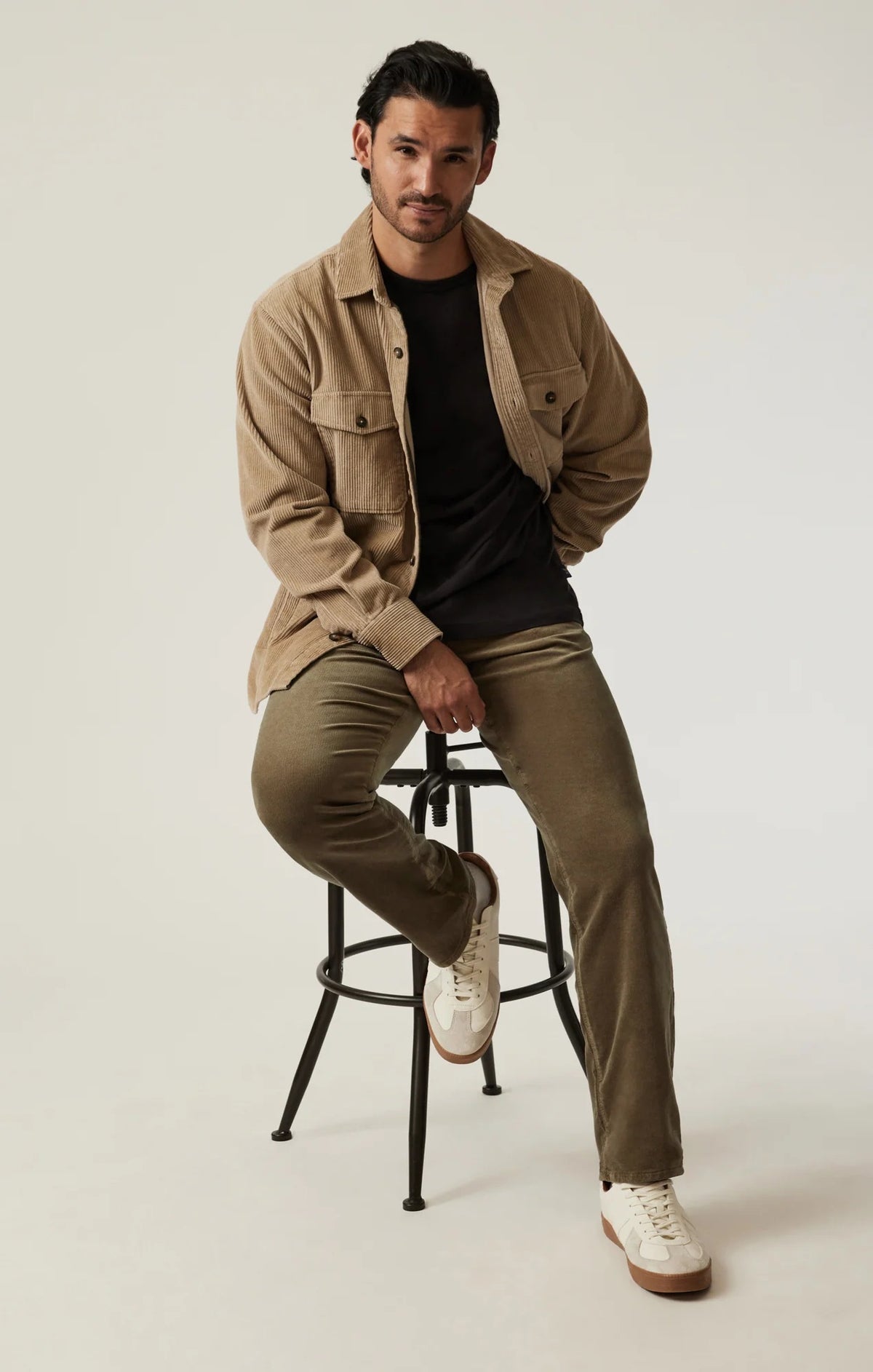 Man wearing 34 HERITAGE - COURAGE STRAIGHT LEG CORDUROY PANTS IN TOBACCO and white sneakers.