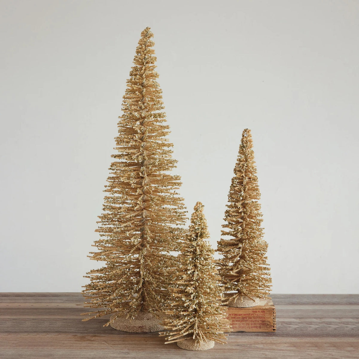 A tall, handcrafted WOOD TREE WITH IRIDESCENT MICA FLAKES featuring shimmering gold-toned flakes and a matching circular base.