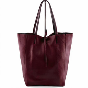 Introducing the LEATHER TOTE BAG IN DARK WINE by JIJOU CAPRI—a spacious Italian leather tote in a deep wine hue, designed with two strong handles and a convenient drawstring closure, ideal for carrying your daily essentials. Shown against a plain white background.