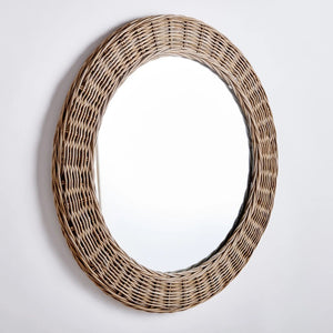 The NAPA HOME AND GARDEN - KYLAN ROUND MIRROR features a natural woven rattan frame, highlighting rustic texture against a white backdrop. Its simplicity and elegance make it ideal for any home decor.