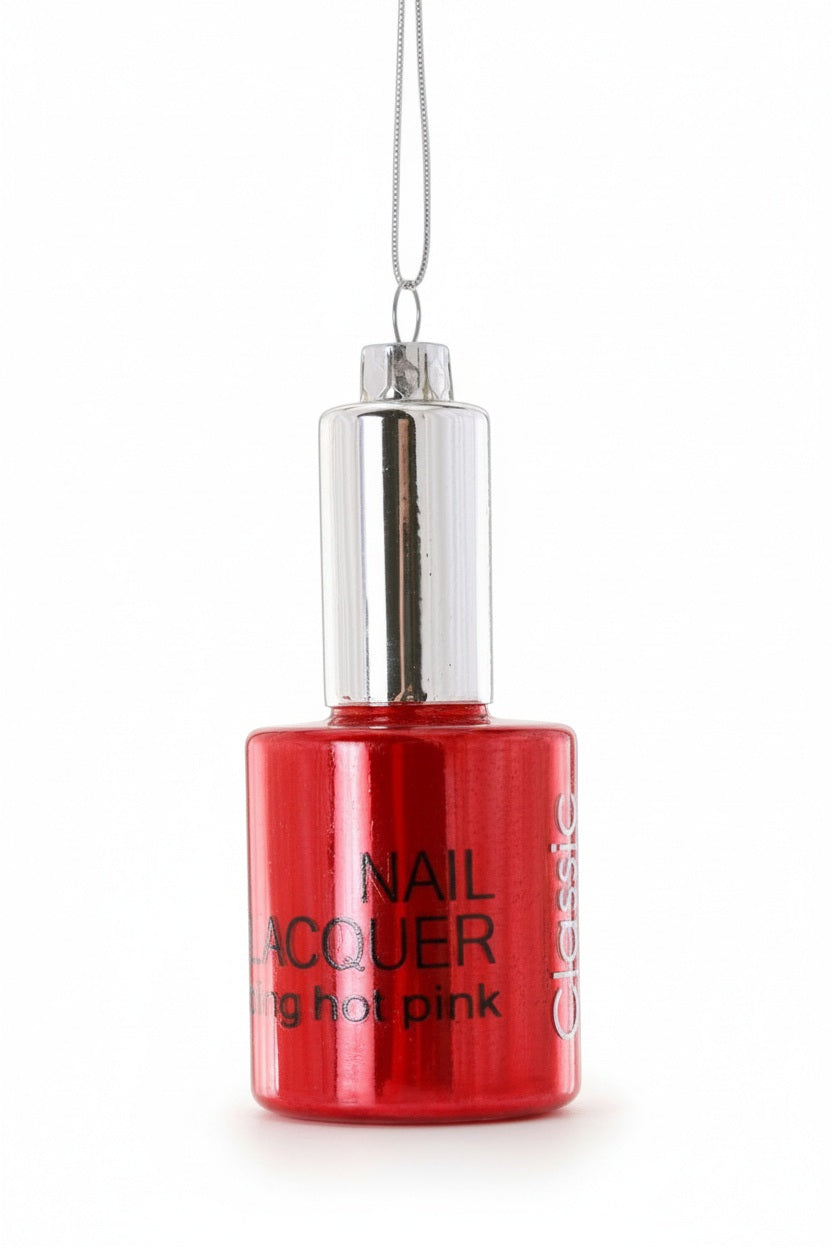 CODY FOSTER NAIL POLISH ORNAMENT, a 3.75-inch glass ornament shaped like a red nail polish bottle with a silver cap and string.