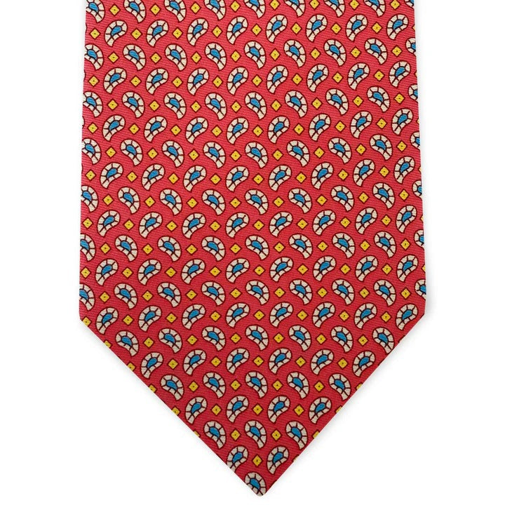 The BIRD DOG BAY Pablito Paisley Silk Tie in fuchsia is handmade in New York, featuring a colorful repeating pattern with blue, yellow, and white accents.