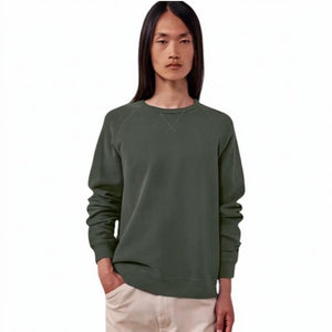 A person with long straight brown hair wears the HARTFORD - LIGHT FLEECE SWEATSHIRT IN ZINC, looking directly at the camera with a neutral expression against a plain light background.