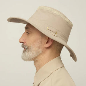 A man with a gray beard wears the TILLEY - AIRFLO HIKERS HAT T4MO-1 IN KHAKI OLIVE, featuring UPF 50+ sun protection, and a matching collared shirt, shown in profile against a plain light background.