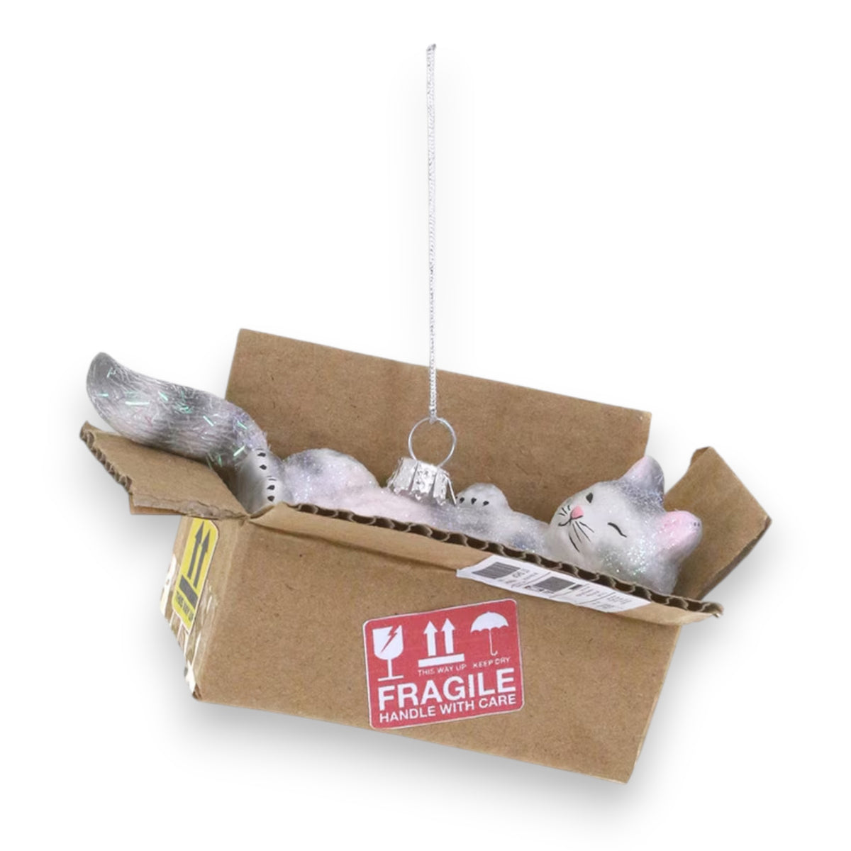 The CODY FOSTER BEST CAT TOY ORNAMENT features a gray cat lounging in a &quot;FRAGILE HANDLE WITH CARE&quot; box, complete with silver hanging loop—an ideal festive gift for collectors and design lovers.