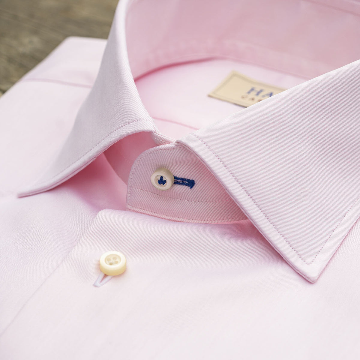 The HAGEN - COTTON DRESS SHIRT IN LIGHT PINK features premium cotton, a modern spread collar with a "Hagen" label, white buttons, and a classic single cuff.