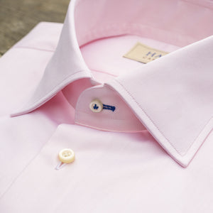 The HAGEN - COTTON DRESS SHIRT IN LIGHT PINK features premium cotton, a modern spread collar with a "Hagen" label, white buttons, and a classic single cuff.