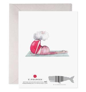 The E. FRANCES - YOGA SANTA GREETING CARD by E. FRANCES PAPER shows Santa in striped pajamas doing shavasana on a yoga mat, with "SHAVASANTA" above him. Proudly made in the USA.