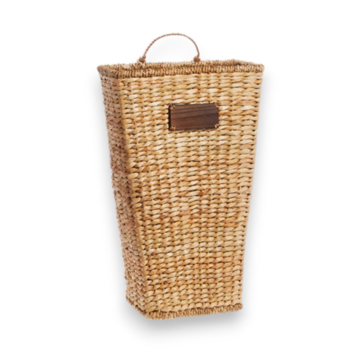 Introducing the WALL BASKET - LARGE by RAZ IMPORTS: A tall, rectangular wicker basket with a tapered base and a small wooden label on the front. Made from light-colored woven natural fibers, including water hyacinth, it features a woven handle on top. Perfect for decorative use, it&#39;s photographed against a white background.