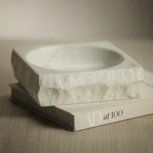 The ZODAX ROCK FINISH MARBLE SQUARE BOWL is crafted from premium white marble, featuring rough, unfinished edges and a smooth, shallow center.