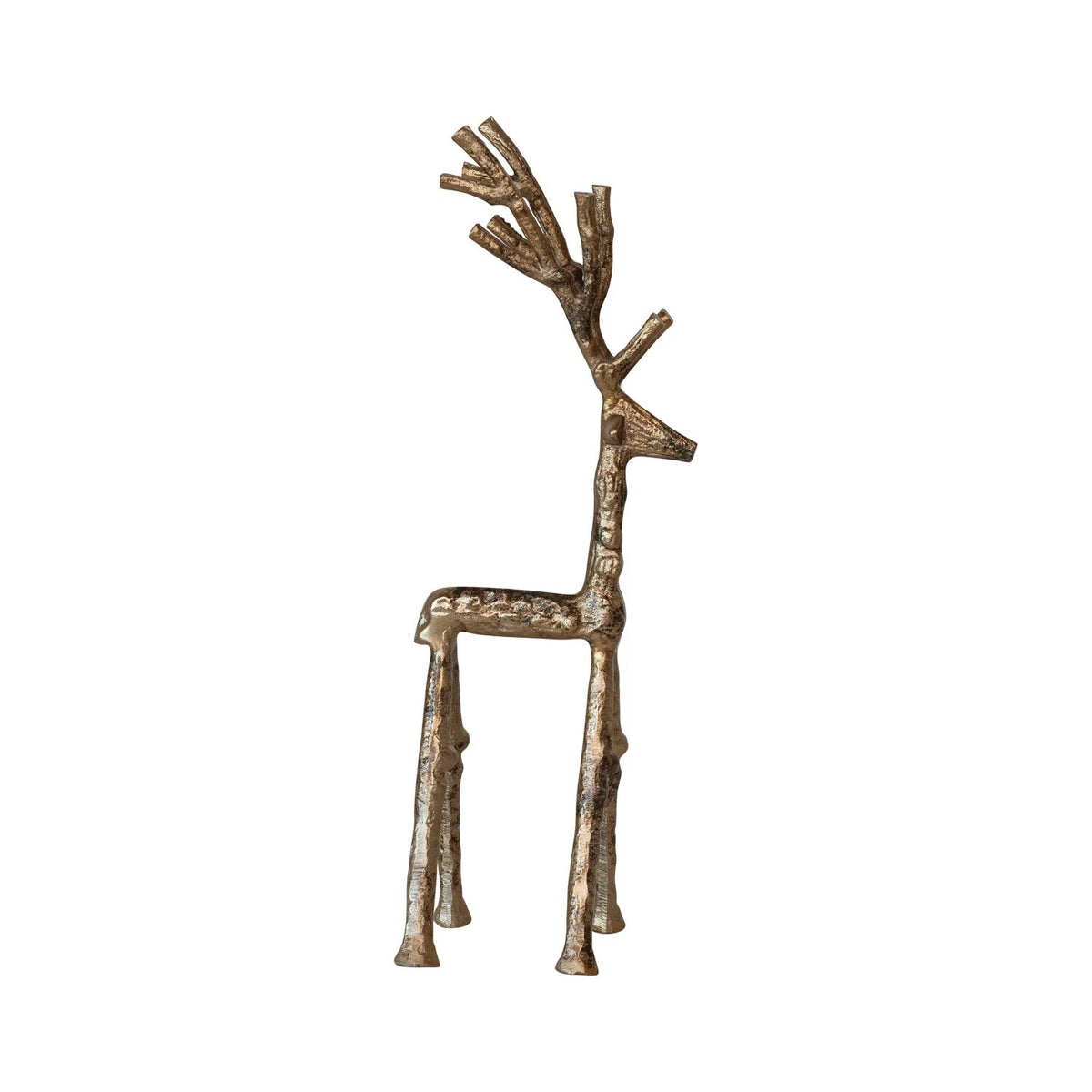 Two metallic reindeer figurines—a CREATIVE COOP CAST ALUMINUM TWIG DEER in an antique gold finish and an abstract long-legged deer—stand beside a small white bottlebrush tree on a glitter-dusted wooden surface.