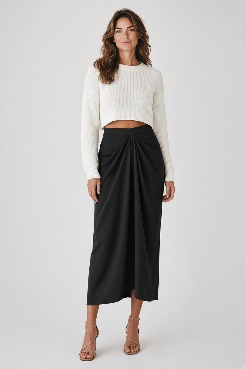 A person wearing a cropped white sweater and a MEIMEIJ - FRONT GATHER MIDI SKIRT, an elegant black midi skirt with a gathered front.
