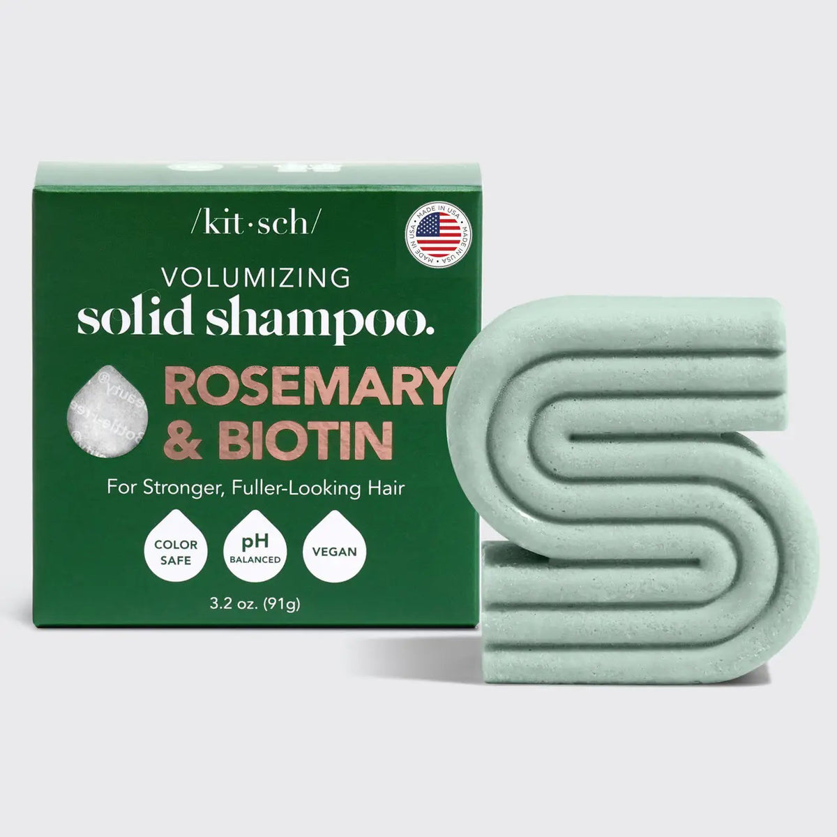 A green KITSCH box labeled “Rosemary and Biotin Volumizing Solid Shampoo Bar” stands behind a matching bar for hair growth; the 3.2 oz (91g) vegan formula is color safe and pH balanced.