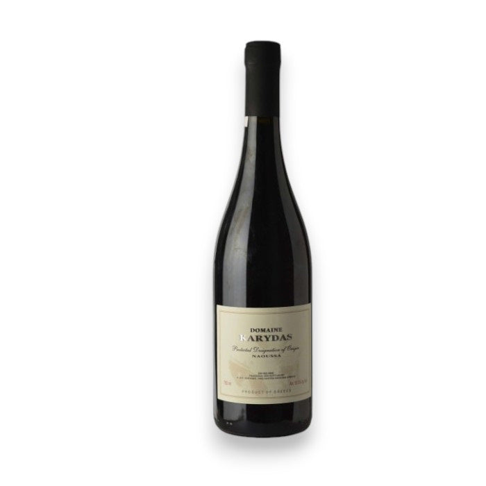 The wine bottle, DOMAINE KARYDAS XINOMAVRO 2020 by WINE: KELLOGG SELECTIONS, features a dark glass with a cream label bearing unclear text and is topped with black foil. It evokes dark cherry notes against a plain white background.