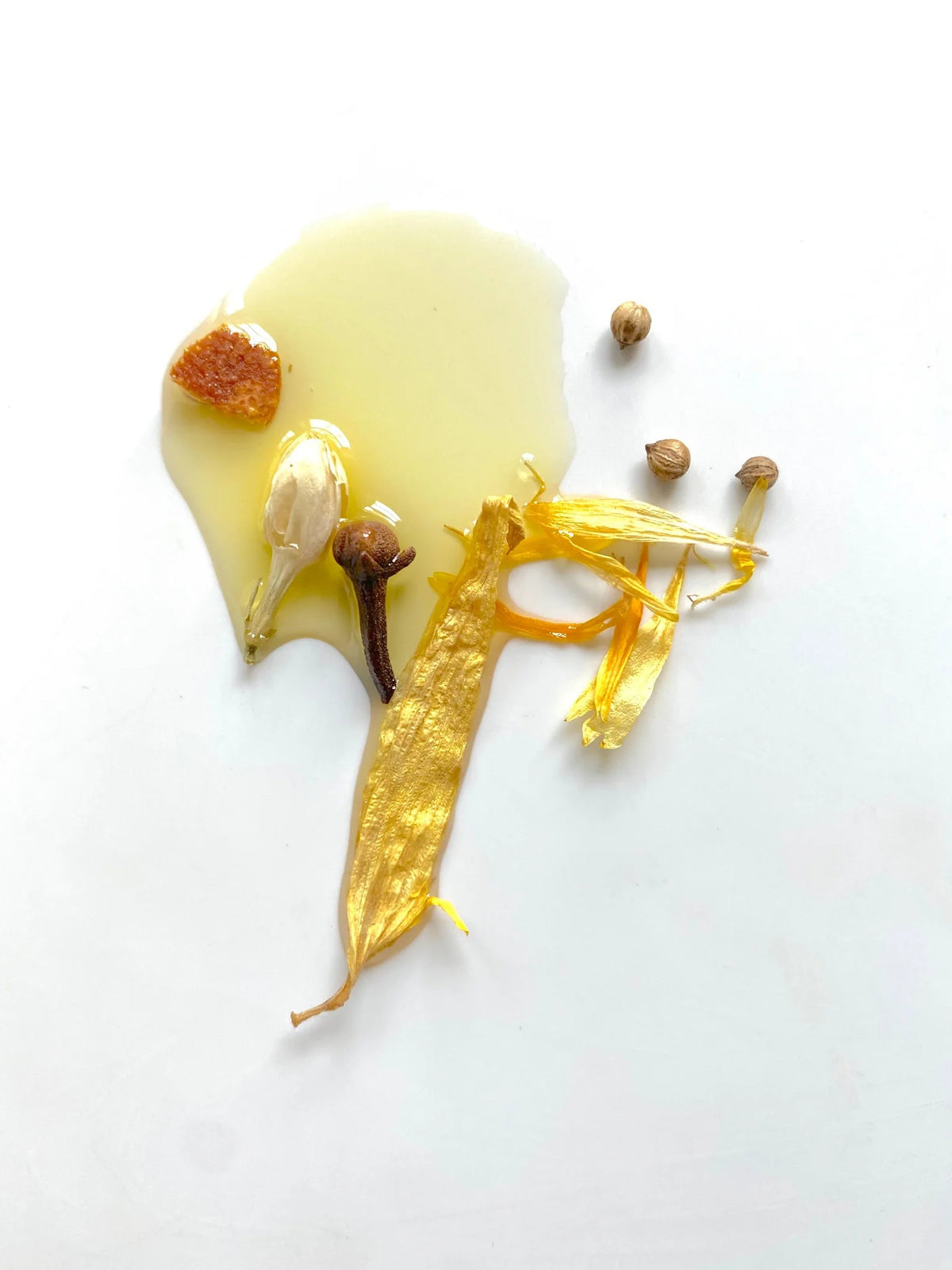 A clear glass bottle with a silver cap holds yellow relaxing body oil infused with small flower petals. The label reads “MADISON AND GREEN - ALONE TIME RELAXING AROMATHERAPY BODY OIL MINI,” highlighting an essential oil blend by MADISON GREEN crafted to help you unwind and relax.