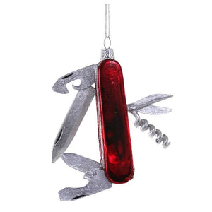 A 3.5-inch GLASS SWISS ARMY KNIFE ORNAMENT by Cody Foster, shaped like a multi-tool pocket knife with a red handle and silver folded blades.