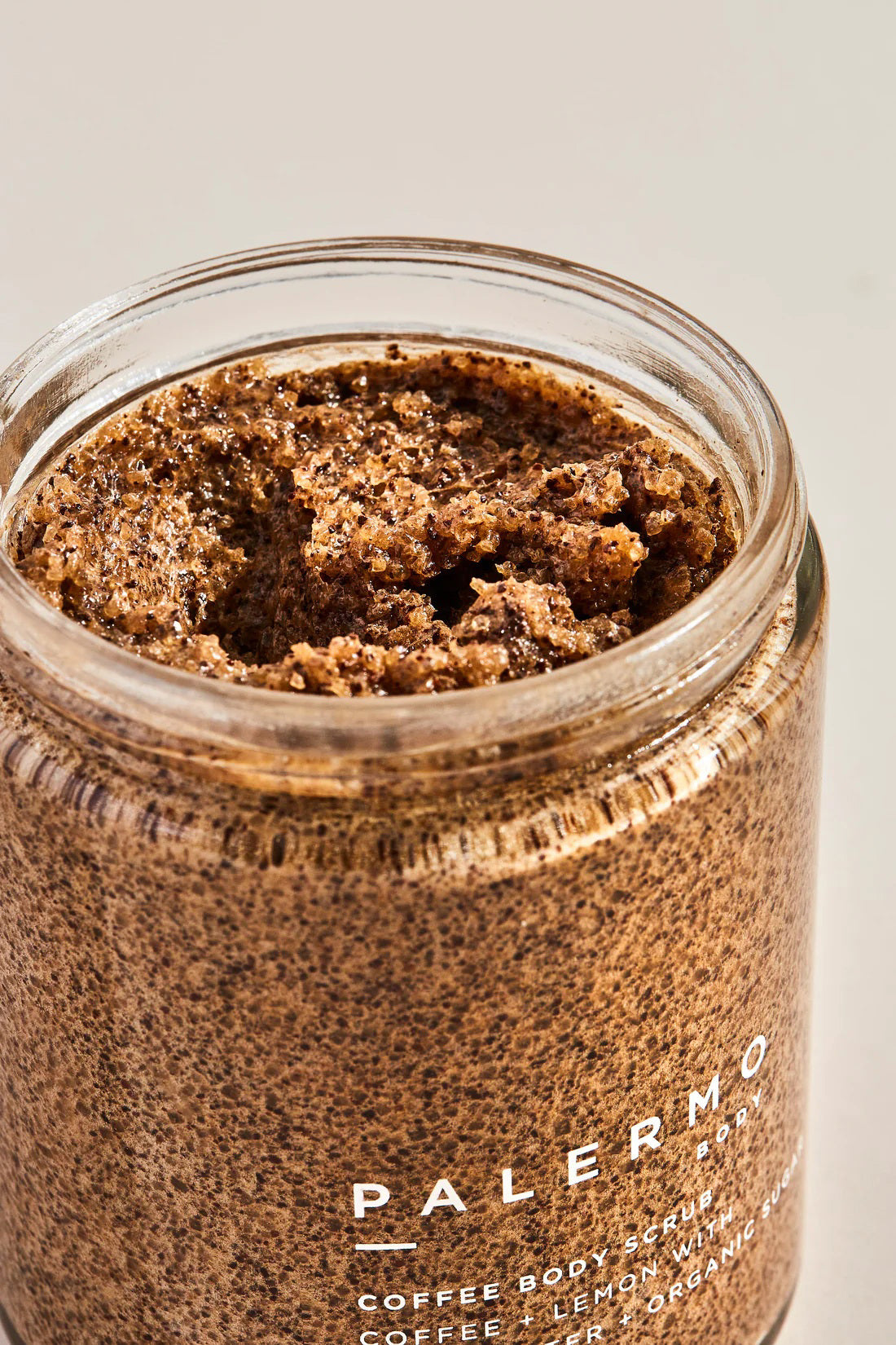 A jar of PALERMO BODY - COFFEE &amp; LEMON BODY SCRUB is shown against a white background. The organic coffee scrub, featuring lemon, shea butter, moisturizing coconut oil, and organic sugar, comes with a black lid. The label details the product information and the quantity is 8.5 oz / 240 g.
