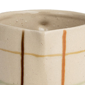 Close-up of the HAND-PAINTED STONEWARE PITCHER by CREATIVE COOP, showcasing an artisanal beige surface with a grid of brown, orange, and light green, plus small dark speckles for added charm.
