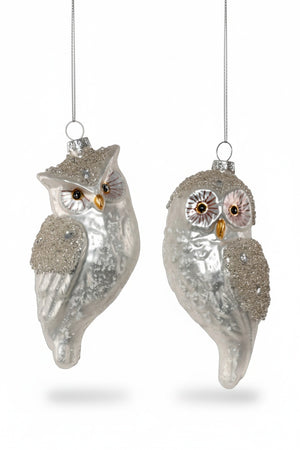 Two silver, glass SILVER OWL ORNAMENTs in assorted styles hanging from silver strings.