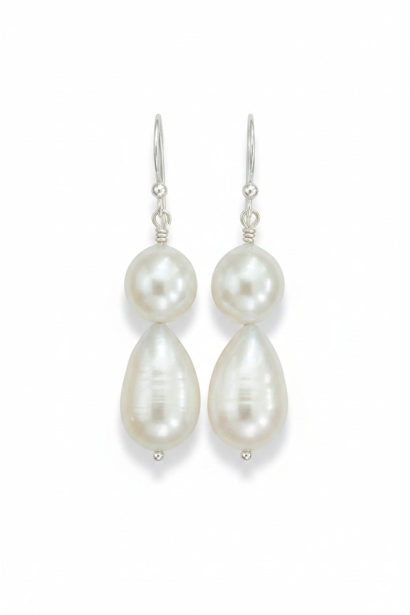 The ANN LIGHTFOOT - DOUBLE DROPLET FRESHWATER PEARL EARRINGS feature teardrop-shaped white pearls on sterling silver hooks, shown against a plain white background.