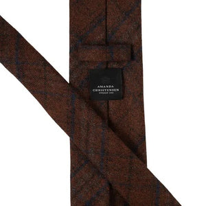 A rust-colored checked wool tie from Amanda Christensen, featuring a subtle checked pattern in varying shades of rust, shown on a white background.