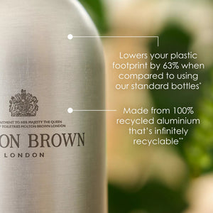 A silver recycled aluminium MOLTON BROWN bottle with pump, labeled "ORANGE & BERGAMOT BODY WASH INFINITE BOTTLE," features citrus and orange neroli fragrance and a yellow tag hanging from the neck.