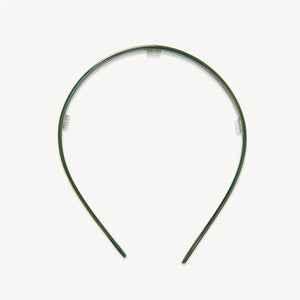 The MACHETE Ultralight Thin Headband in Meadow is a simple, slim green plastic accessory with a slight sheen, shown against a plain white background.