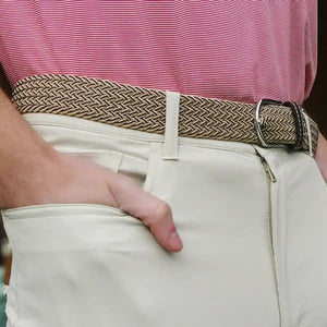 The ROOSTAS TUCSON WOVEN STRETCH BELT features khaki and brown weave, a silver buckle, brown leather accents with stitched logo at the ends for style.
