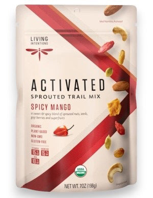 A white and red bag of LIVING INTENTIONS SPROUTED TRAIL SPICY MANGO features a mix of organic, plant-based, non-GMO nuts, seeds, and dried fruit. The label highlights its sprouted trail mix goodness.