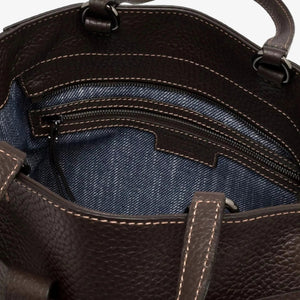 The GIANNI CHIARINI - MIRANDA HANDBAG IN ESPRESSO is a dark brown handbag crafted from pebbled, hammered leather, featuring two handles and a distinctive knotted strap detail across the front. It comes finished with a removable shoulder strap and is shown against a white background.