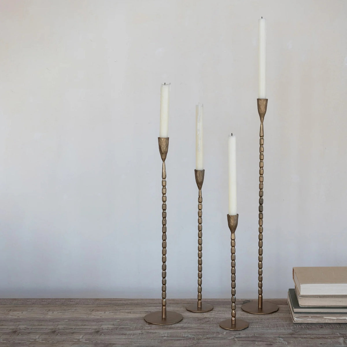 A close-up of the CREATIVE COOP CAST IRON TAPER HOLDER IN BRASS FINISH, EXTRA LARGE, featuring a textured vertical ribbed pattern and a rounded tapered cup at the top, set against a plain white background.