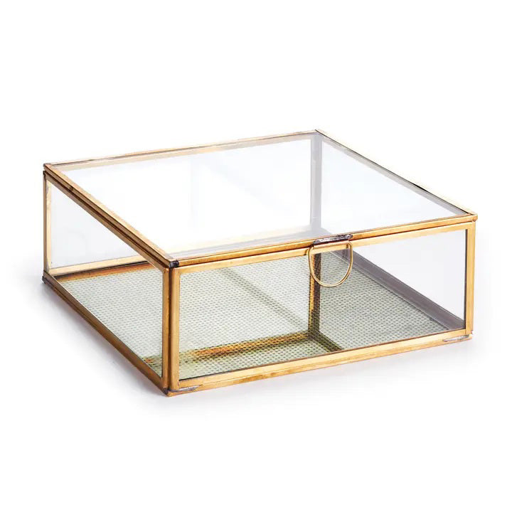 The NAPA HOME AND GARDEN - LARGE ARWEN BOX features a gold frame and glass with a brass lid. It boasts a contemporary look, with transparent sides and top, and a textured gold-finished bottom. The box includes a small circular handle for convenient opening, ideal for any stylish interior.